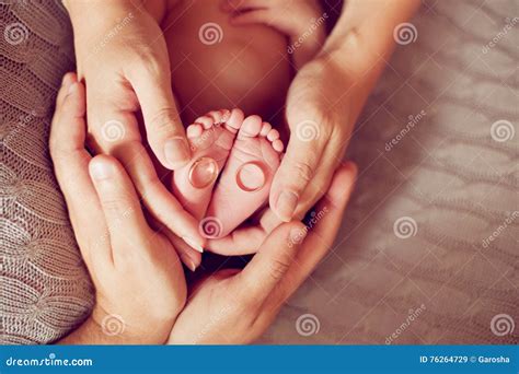 Mani di genitori che tengono i piedini di un bambino