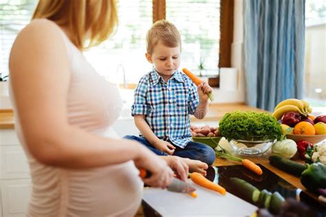 Genitore che prepara un pasto con il bambino nella sdraietta
