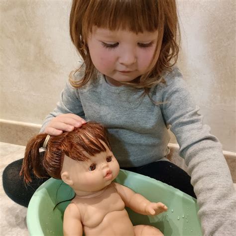 Bambina che gioca a fare il bagnetto alla sua bambola