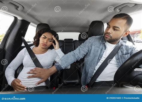 Donna incinta che guida un'auto con un sorriso