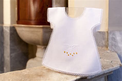 Bambino avvolto nella veste bianca battesimale