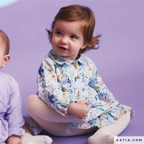 Particolare di un vestito da neonato con un nastro.