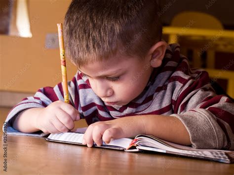 bambino che scrive su un quaderno colorato