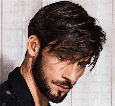Uomo con viso rotondo e capelli lunghi voluminosi