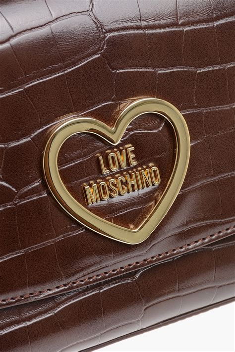 Dettagli in metallo dorato su una borsa Moschino