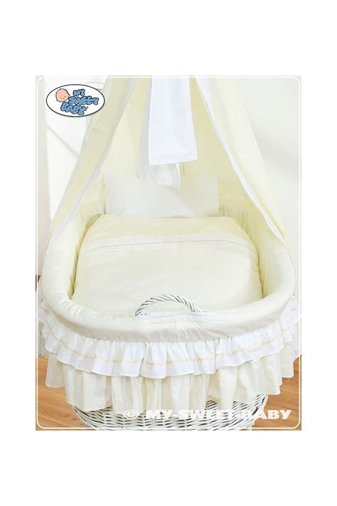 Culla in vimini bianca con neonato addormentato