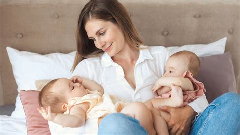 Mamma che allatta gemelli con cuscino specifico