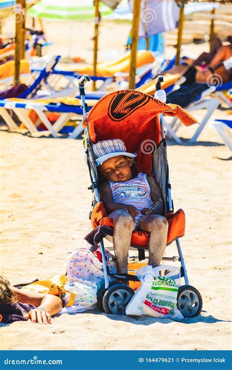 Bambino in un passeggino sulla spiaggia