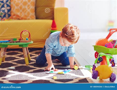 Bambino felice sul seggiolone con giocattoli