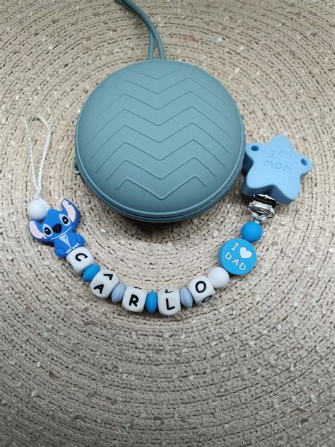 Una raffinata catenella portaciuccio personalizzata in silicone posizionata su una superficie neutra, evidenziando la qualità dei materiali e la precisione del nome stampato.