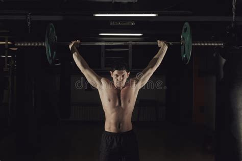 Atleta che solleva un bilanciere in palestra indossando abbigliamento tecnico