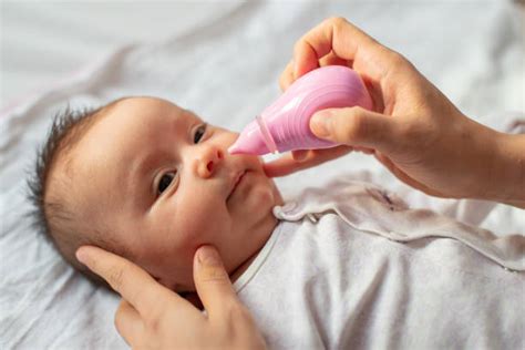 Genitore che usa l'aspiratore nasale su un bambino