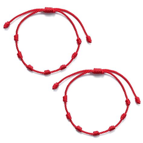 Braccialetto rosso al polso con simboli di protezione