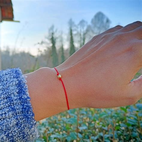Braccialetto di filo rosso annodato a mano