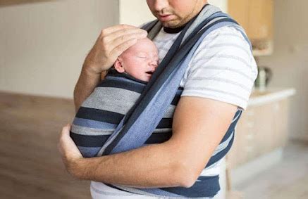 Genitore che porta il bambino in fascia