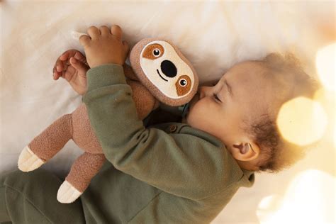 Bambino che dorme abbracciato a un doudou morbido