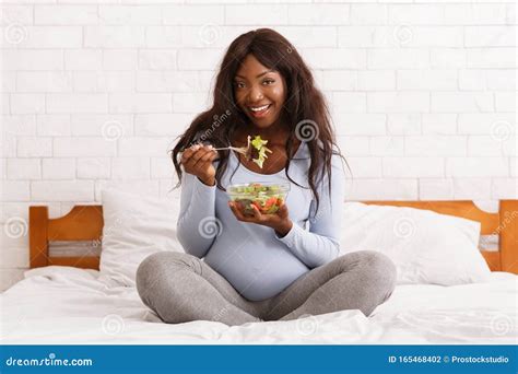 Donna che mangia cracker a letto