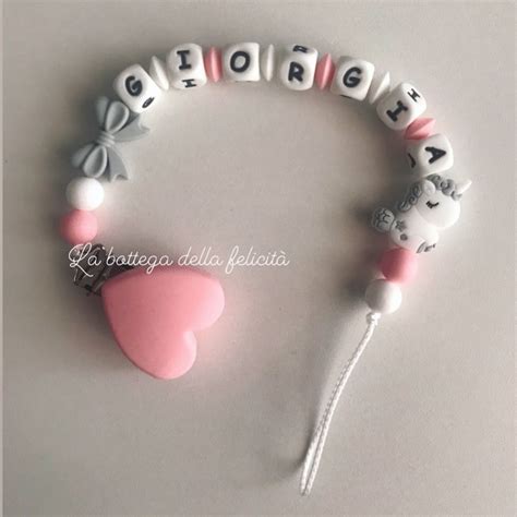 Esempio di una catenella portaciuccio nei toni del rosa con perline di legno e scritta personalizzata