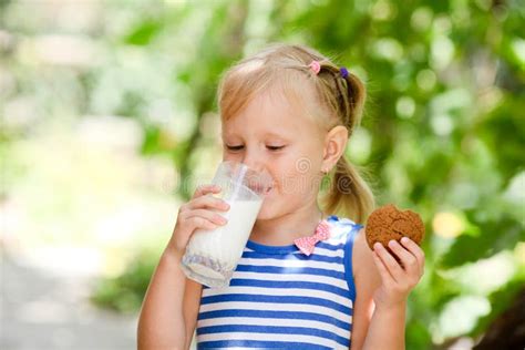 Bambino che beve latte con biscotti