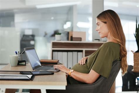 Donna incinta al lavoro in un ufficio moderno