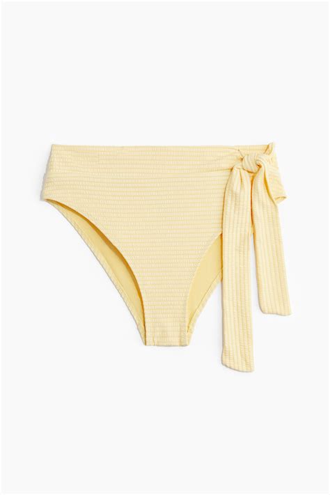 Donna incinta con un bikini a vita alta in spiaggia