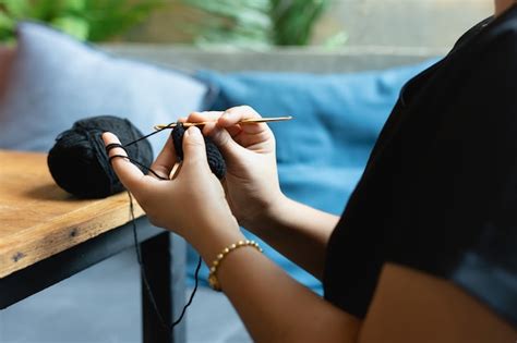 dettaglio di mani che lavorano all'uncinetto accanto a una culla