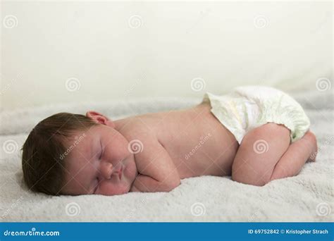 Immagine di un neonato che dorme serenamente con un pannolino