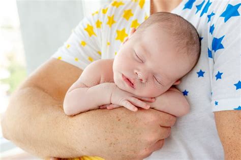 Padre che tiene in braccio il neonato e lo guarda con tenerezza