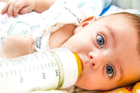 Bambino neonato che beve da un biberon speciale