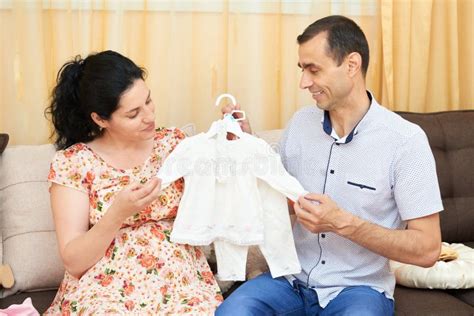 Donna incinta che acquista vestiti per neonato