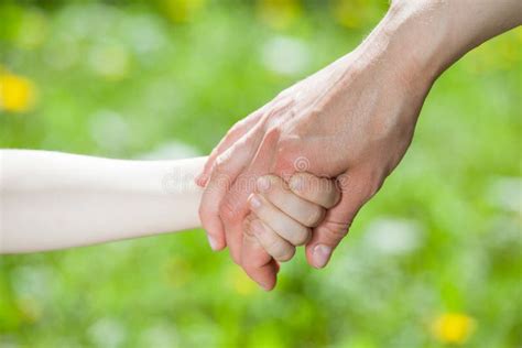 Mani di adulto e bambino che si tengono