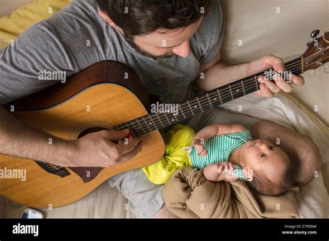 Father playing guitar to a baby