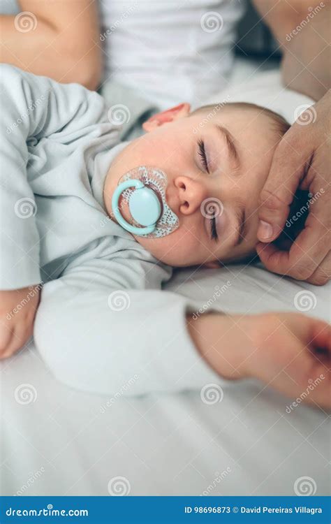 Bambino addormentato nella culla mentre un genitore canta