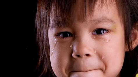 Bambino che piange mentre gli viene cambiato il pannolino