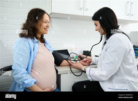 Donna incinta che misura la pressione sanguigna a casa