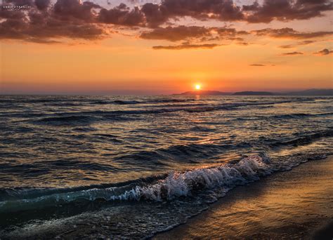 Onde tranquille del mare al tramonto, con colori caldi