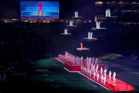 Rihanna during Super Bowl halftime show in red outfit on a suspended platform