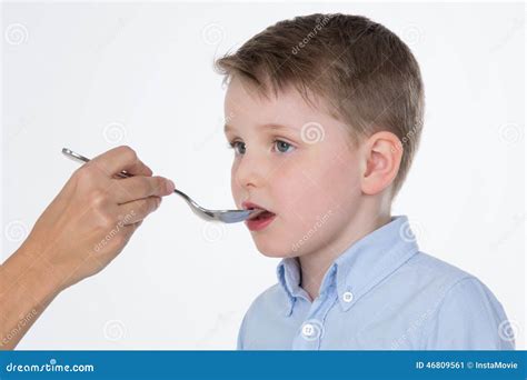 Bambino che prende uno sciroppo da un adulto