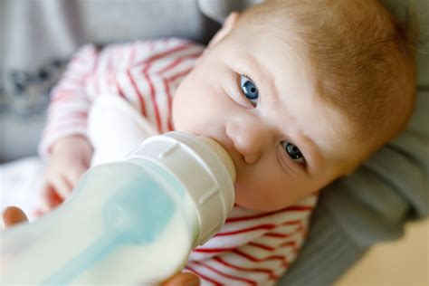 Neonata che beve dal biberon con latte formulato di tipo 1