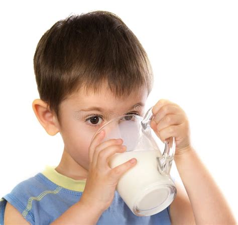 Bambino di circa un anno che beve latte dal bicchiere