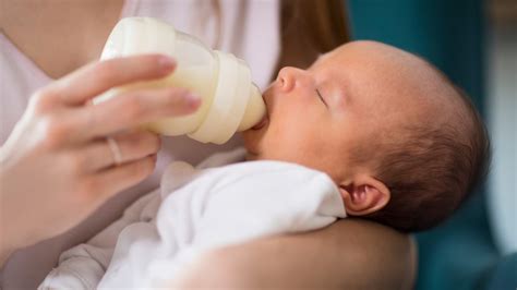 Genitore che allatta al biberon il proprio bambino in un ambiente rilassato