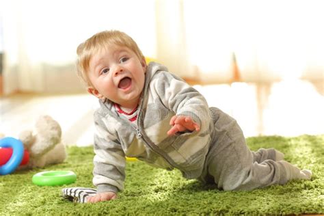 Un bambino che gioca felice su un tappeto morbido e colorato a tema giungla con figure di animali