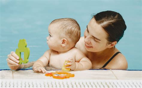 Bambino che gioca in piscina con pannolino acquatico
