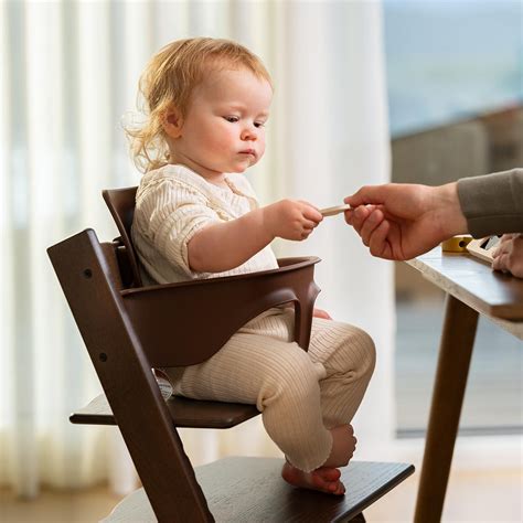 bambino seduto correttamente sul seggiolone Enock con la schiena dritta e i piedi appoggiati