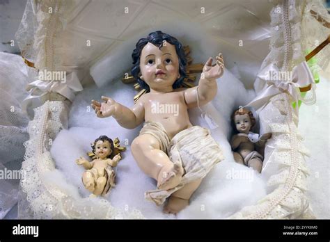 rappresentazione artistica di una culla tradizionale con una statuetta del Bambino Gesù