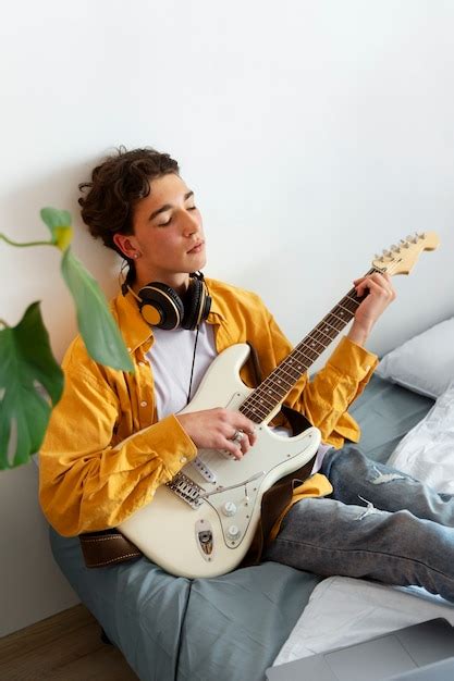 ragazzo che suona la chitarra elettrica in una stanza creativa