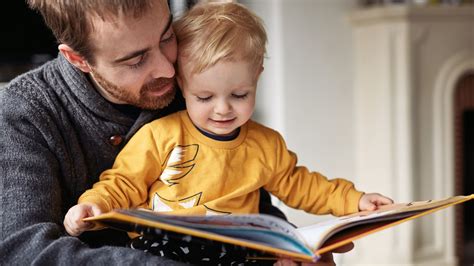 Bambino che legge un libro con i genitori