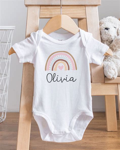 Fotografia di un set regalo neonato che include body, ciuccio e portaciuccio personalizzato