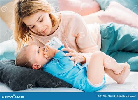 Madre che alimenta il suo bambino con il biberon e madre che allatta al seno