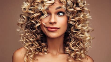 Donna con capelli ricci sorridente durante o dopo la gravidanza